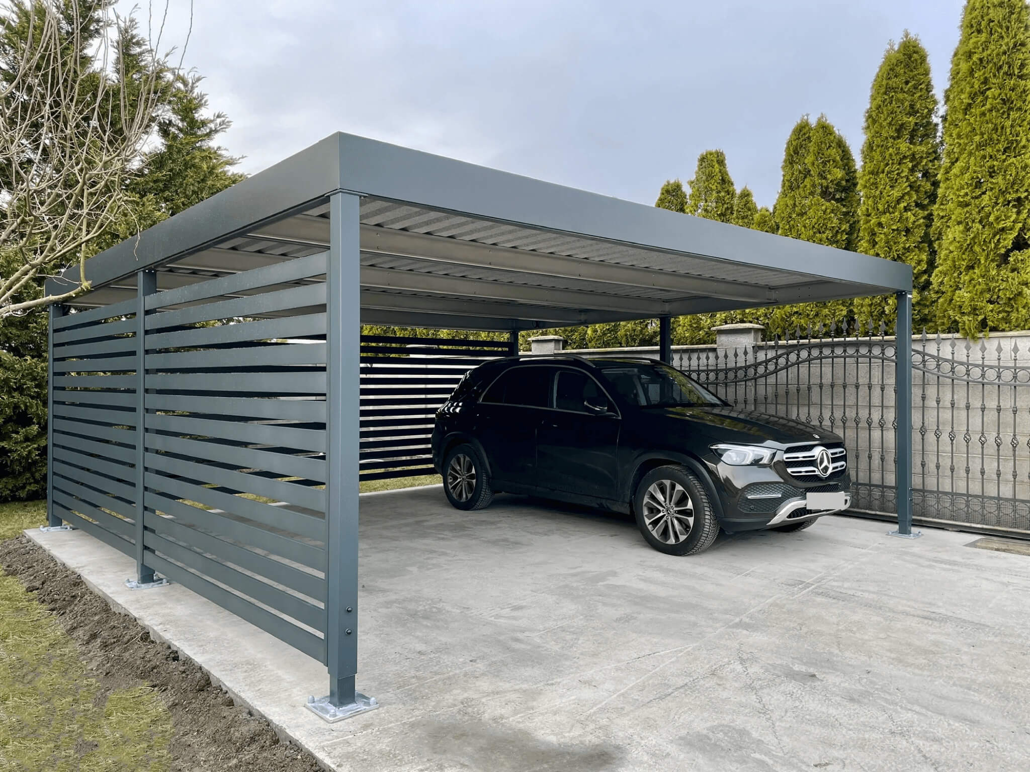 Moderný oceľový prístrešok pre auto so strechou trapézového profilu poskytujúci efektívnu ochranu pred počasím, cenovo dostupný od Koverta